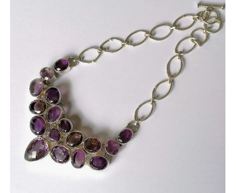 An seventeen-stone amethyst bib necklace on a silver setting and link chain, stamped 925, largest stone 20mm x 15mm, 72g