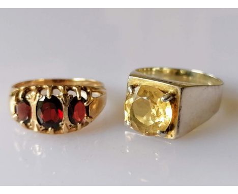 A 9ct yellow gold graduated three-stone garnet ring in a claw setting, hallmarked, 3.73g and a silver gem-set ring, both size