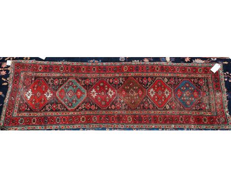 A KAZAKH RUGCaucasian, the field filled with four concentric polychrome diamonds, an ivory hooked bracket border, 224cm x 122