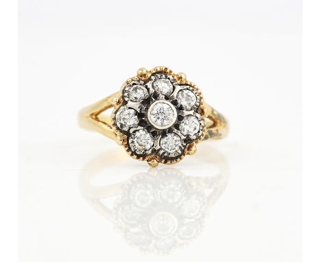 A GOLD AND DIAMOND EIGHT STONE CLUSTER RINGThe diamond cluster ring mounted with the principal circular cut diamond at the ce