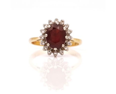 AN 18CT GOLD RHODOLITE GARNET AND DIAMOND SET OVAL CLUSTER RINGClaw set with the oval cut garnet in a surround of circular cu