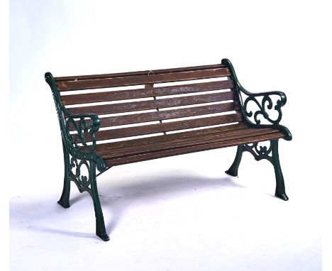 AN EARLY 20TH CENTURY GREEN PAINTED CAST IRON GARDEN BENCHWith slatted wooden seat, 126cm wide; 78cm high