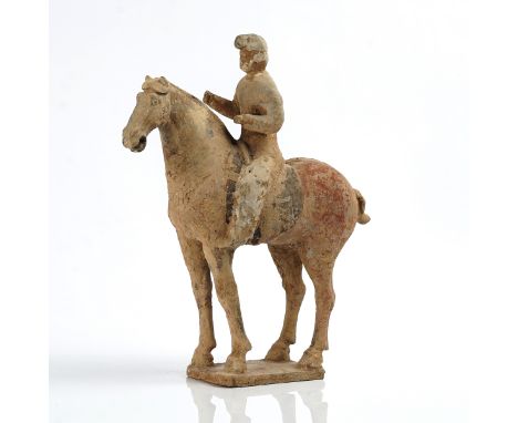 A CHINESE POTTERY EQUESTRIAN FIGUREProbably Han dynastyThe rider seated with hands raised as if to hold the reins, the horse 