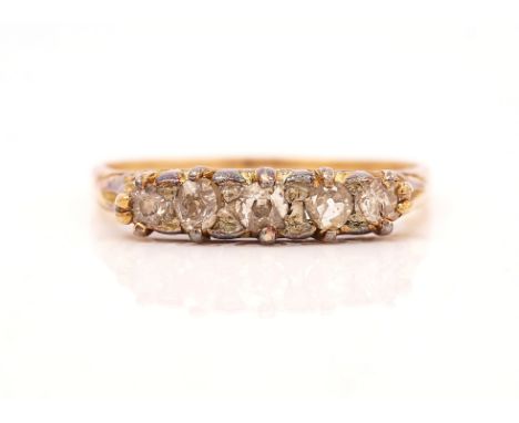 A GOLD AND DIAMOND SET FIVE STONE RINGMounted with a row of graduated cushion shaped diamonds, the mount decorated with scrol