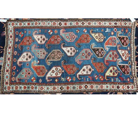 A KAZAKH RUGCaucasian, the indigo field with rows of large botehs, animals and motifs; an ivory star and bracket border 198cm