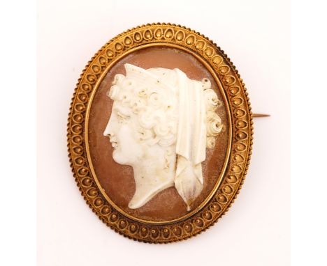 A VICTORIAN GOLD MOUNTED OVAL SHELL CAMEO BROOCHCarved as the portrait of a classical lady, the gold mount with applied bead 