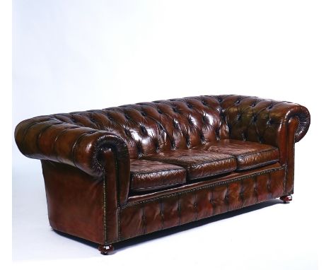 A 20TH CENTURY STUDDED BROWN LEATHER UPHOLSTERED CHESTERFIELD SOFAOn bun feet, 217cm wide; 75cm highCondition report:&nbsp;Va