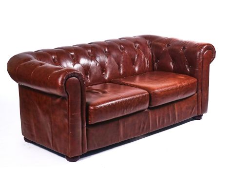 A 20TH CENTURY BROWN LEATHER UPHOLSTERED CHESTERFIELD SOFAOn bun feet, 85cm wide; 70cm high