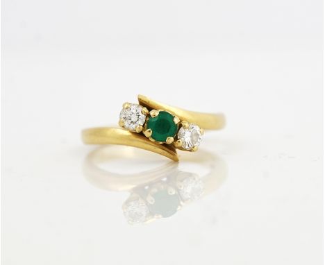 AN 18CT GOLD, EMERALD AND DIAMOND THREE STONE RINGClaw set with a circular cut emerald between two circular cut diamonds, in 