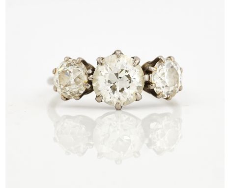A DIAMOND SET THREE STONE RINGClaw set with the principal cushion shaped diamond at the centre between two smaller cushion sh