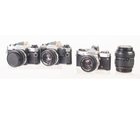 THREE OLYMPUS 35mm SLR ROLL FILM CAMERAS, comprising: TWO OM10's, and an OM1, all fitted with 50mm, f1.8 lenses, together wit