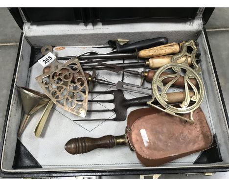 A case of old kitchen tools, funnel trivets, copper shovel etc.