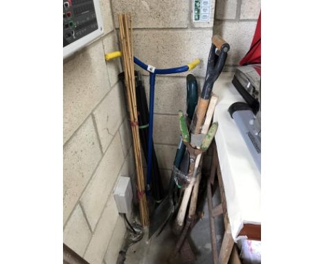 A quantity of garden tools, canes etc.