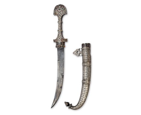 A WHITE-METAL MOUNTED MOROCCAN JAMBIYA DAGGER, late 19th to early 20th century, with curving 9in. blade edged for half its le