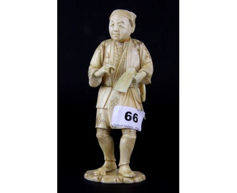 A 19th Century Japanese carved ivory figure of a man carrying tools, H. 17cm.