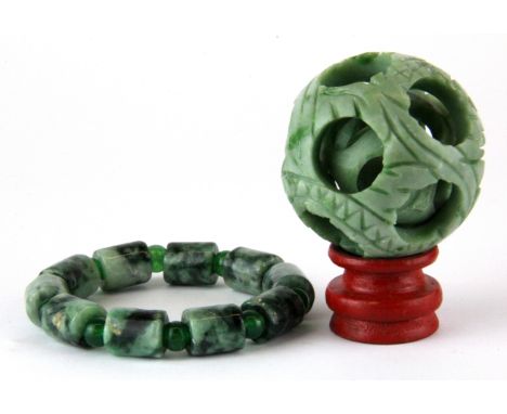 A Chinese carved green jade and green cornelian bracelet together with carved ball in ball.