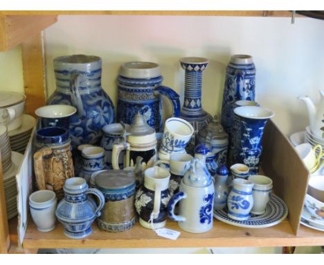 A collection of German salt-glazed stoneware, largely steins and jugs with blue enamel detail 