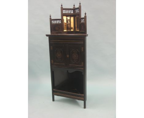 A Victorian ebonised wood corner cabinet, over-shelf fitted with twin bevelled mirror plates, panelled cupboard base with ope