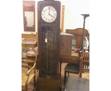 An Art Deco oak longcase clock, circular dial with Arabic numerals, Enfield movement chiming on eight rod gongs, three weight