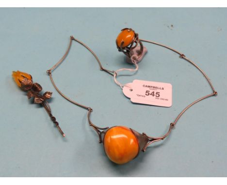 A matched suite of amber jewellery, necklace, large ring and stick-pin, all with white metal mounts