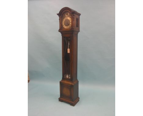 A 1920's solid, dark oak grandmother clock, traditional arched dial indicating Westminster, Winchester and Whittington chimes