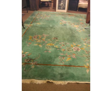 A Chinese wool carpet, floral designs against a green field, 9ft.