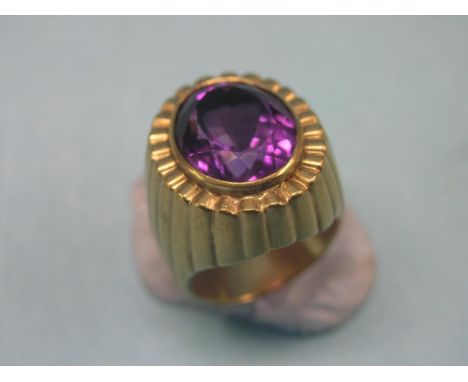 A large gentleman's yellow metal dress ring, set single oval, faceted amethyst, size R, unmarked