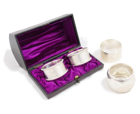 A Victorian silver pair of napkin rings, Birmingham 1873, with engine turned decoration and gadrooned borders, initialled, we