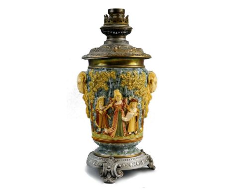 A Continental majolica table oil lamp base, of slightly tapering circular form  moulded with two rams head handles and childr