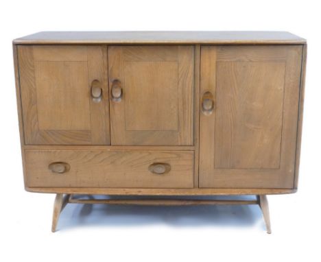 An Ercol light elm side cabinet, with rounded oblong top over a two door cupboard with drawer below flanked by a cupboard doo