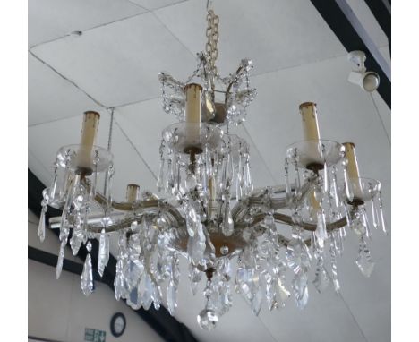 A cut clear glass chandelier, the hollow baluster stem supporting two graduated dishes with swags, lozenges and prism drops, 