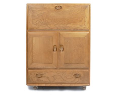 An Ercol light elm cocktail cabinet or writing unit, the plain oblong top over a fall front with partly fitted interior, in t