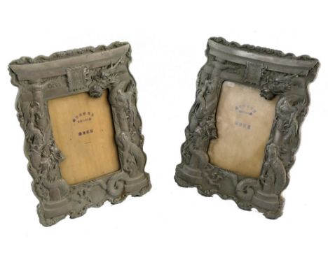 A pair of Chinese white metal easel photograph frames, of oblong form each as a gateway arch with dragons coiled around the s