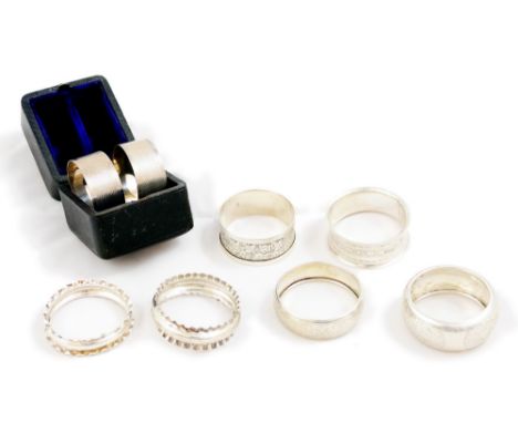 A Victorian silver pair of napkin rings, Sheffield 1877, with engine turned decoration, vacant cartouches, case and six other