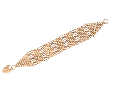 A GATE LINK BRACELETin 9ct gold, comprising a series of stylised gate links, secured with an antique heart-shaped padlock cla