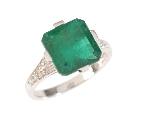 AN EMERALD AND DIAMOND RINGin 18ct white gold, set with a step-cut emerald of c.4.72 carats, to stylised shoulders set with s