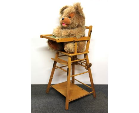 A vintage child's highchair and occupant.