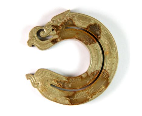 A Chinese Warring States style brown jade model of a coiled dragon, Dia. 6.8cm.