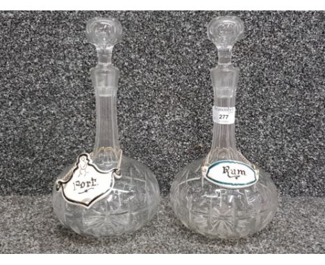 A pair of cut glass decanters with ceramic port and rum labels