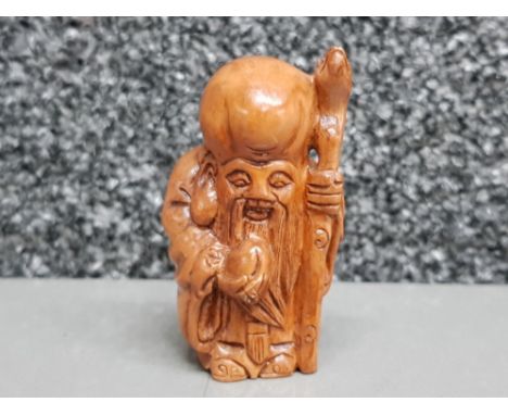 Handcarved hardwood Netsuke in the form of a village elder with staff.