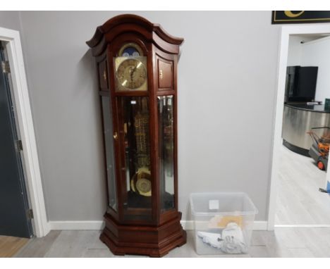 A mahogany Howard Miller grandfather clock with Arabic dial, glass corner shelves, weights and winder 209cm high