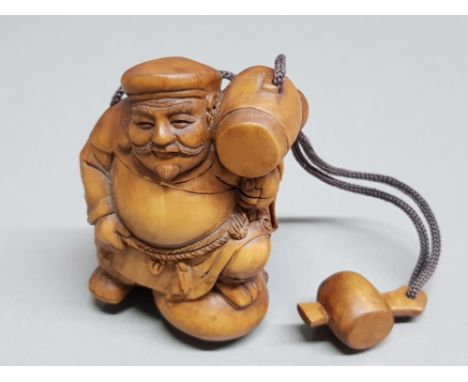 A Japanese carved wood Inro in the form of a man holding a mallet, and a netsuke in the form of a mallet.