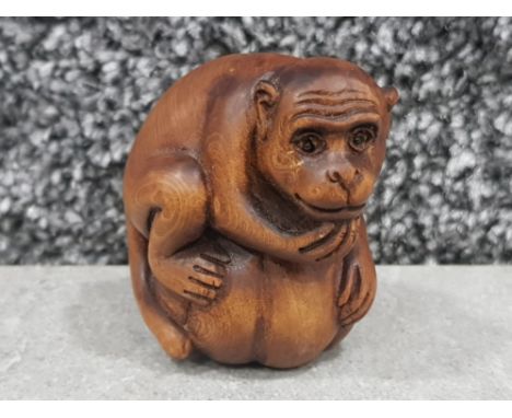Handcarved hardwood Netsuke in the form of Monkey on fruit