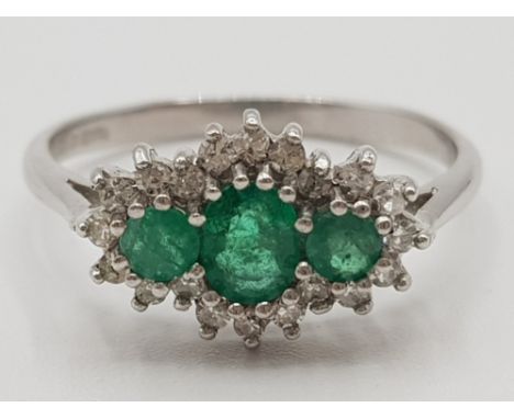 Ladies 9ct white gold emerald &amp; diamond cluster ring featuring 3 emeralds set in the centre surrounded by 20 round brilli