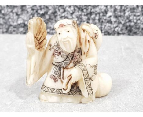 Japanese handcarved bone Netsuke in the form of a village elder with fan