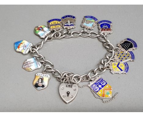 A silver charm bracelet with heart shaped clasp, and various enamel tourist charms, most being silver 24.3g gross.