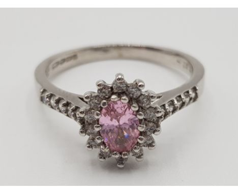 9ct white gold pink stone cluster ring featuring an oval pink stone in the centre surrounded by cubic zirconias size O 2.9g g