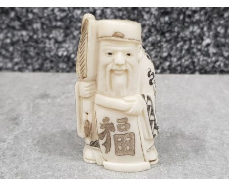 Japanese Hand carved bone Netsuke in the form of a village elder with fan, signed on base