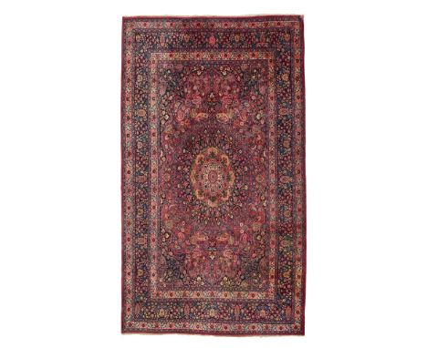  MESHED CARPET EAST PERSIA, LATE 19TH/EARLY 20TH CENTURY the red field with indigo and light brown medallion, indigo spandrel