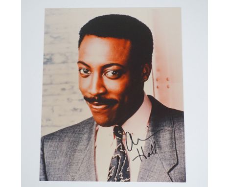 A signed photograph of Arsenio Hall, featuring a close-up portrait of the renowned comedian and talk show host. The autograph